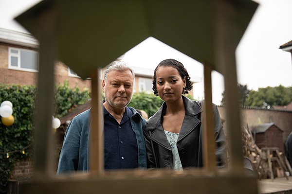 Two people looking through a bird table