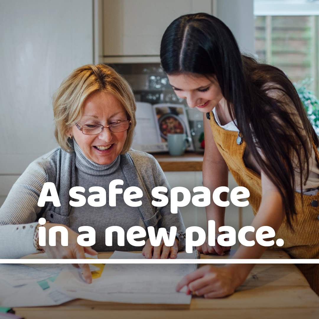 A photograph of two females looking down with a text overlay saying A safe space in a new place