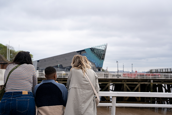 2 adults with a child viewing the deep